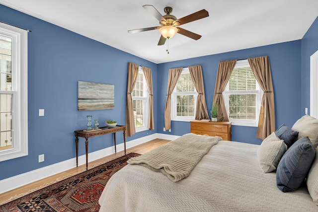 bedroom with baseboards, wood finished floors, and ceiling fan