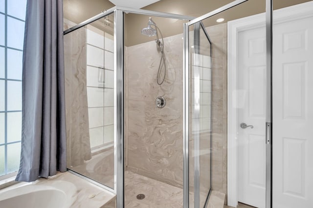 bathroom featuring a stall shower and a tub to relax in