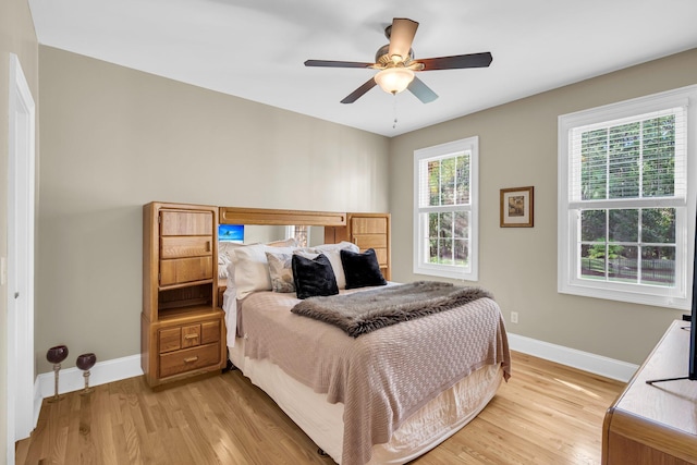 bedroom with baseboards, light wood-style flooring, and ceiling fan