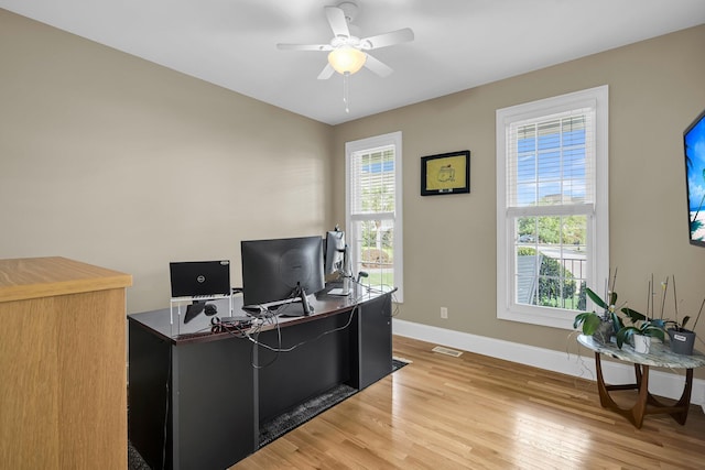 office area featuring baseboards, light wood finished floors, and ceiling fan