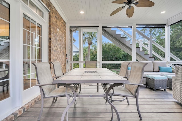 sunroom featuring ceiling fan, outdoor dining area, and an outdoor living space