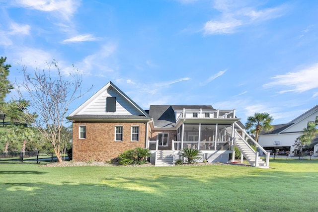 rear view of property with a sunroom, stairs, and brick siding