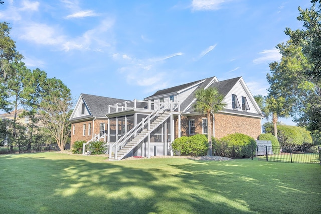 rear view of property featuring brick siding, a sunroom, stairs, and a shingled roof