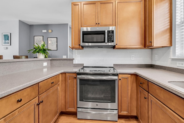 4060 Hartland St, Charleston, SC 29414 - kitchen featuring stainless steel appliances, decorative backsplash, light wood finished floors, light countertops, and brown cabinetry