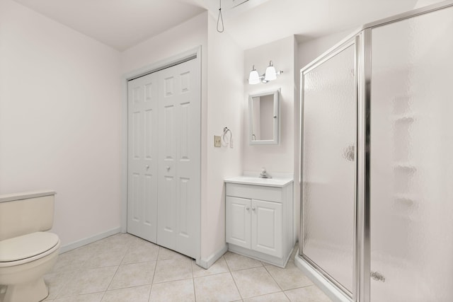 bathroom with tile patterned flooring, vanity, toilet, and walk in shower