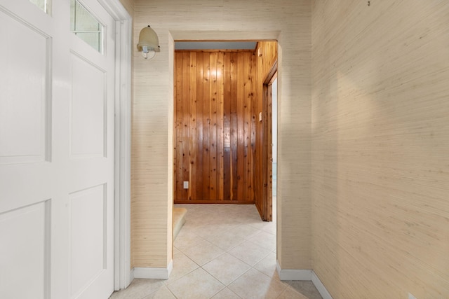 corridor with light tile patterned floors and wooden walls