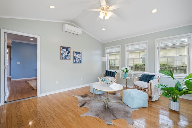 sitting room featuring hardwood / wood-style flooring, a wall mounted AC, crown molding, baseboards, and vaulted ceiling