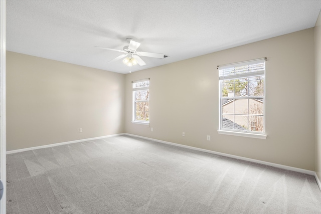 unfurnished room featuring ceiling fan, a textured ceiling, baseboards, and carpet