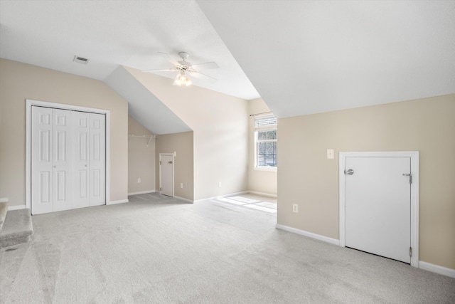 additional living space featuring visible vents, baseboards, lofted ceiling, carpet flooring, and a ceiling fan