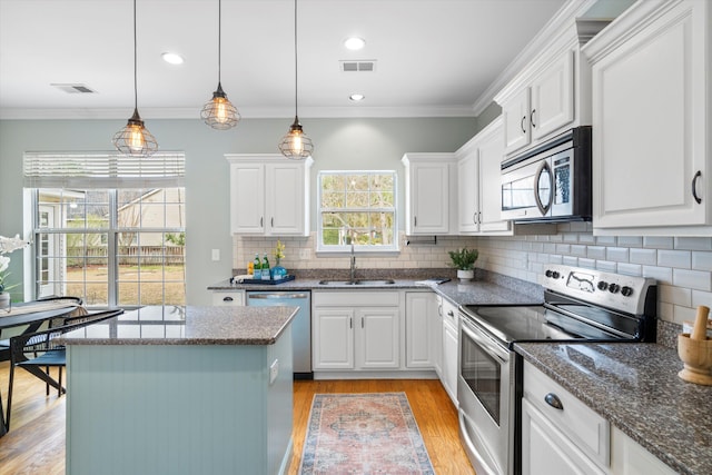 kitchen with visible vents, stainless steel appliances, crown molding, and a sink