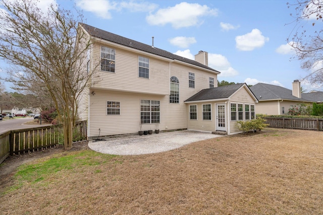 back of property featuring a yard, a patio, a fenced backyard, and a chimney