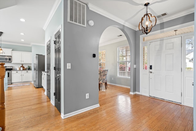 foyer with visible vents, light wood finished floors, and a chandelier