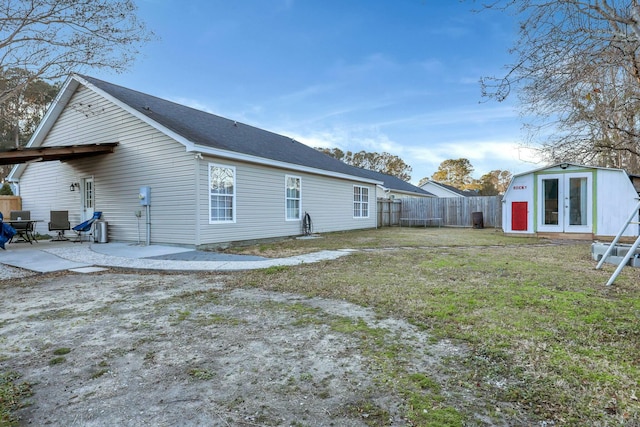 rear view of property featuring a patio, a yard, and an outdoor structure