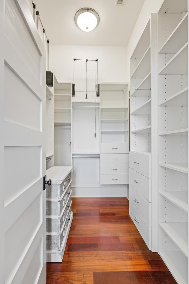 spacious closet with dark hardwood / wood-style floors