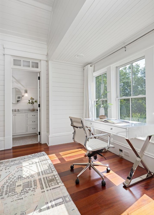 office featuring wood walls, hardwood / wood-style floors, and vaulted ceiling