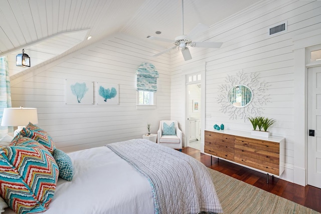 bedroom with lofted ceiling, dark hardwood / wood-style flooring, ceiling fan, and wooden walls