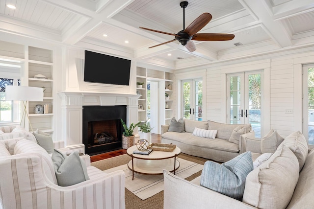 living room with coffered ceiling, ceiling fan, french doors, and built in features