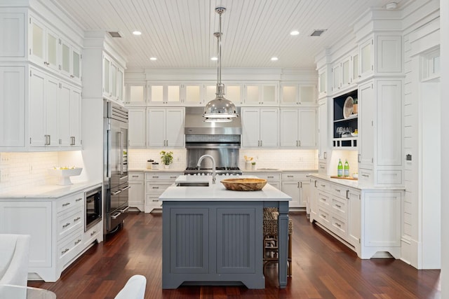 kitchen featuring pendant lighting, a center island with sink, and white cabinets