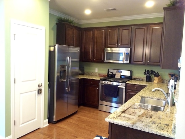 1720 Restoration Ct, Charleston, SC 29414 - kitchen featuring stainless steel appliances, ornamental molding, light stone counters, dark brown cabinetry, and light wood-type flooring
