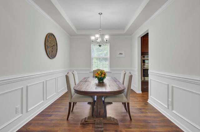 dining area featuring a tray ceiling, dark hardwood / wood-style floors, and ornamental molding