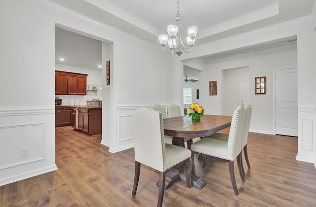 dining room featuring a chandelier, dark hardwood / wood-style flooring, a tray ceiling, and ornamental molding