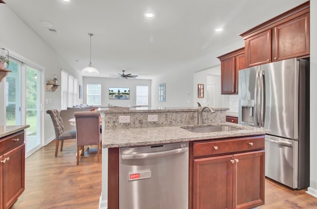 kitchen with ceiling fan, sink, stainless steel appliances, and light wood-type flooring