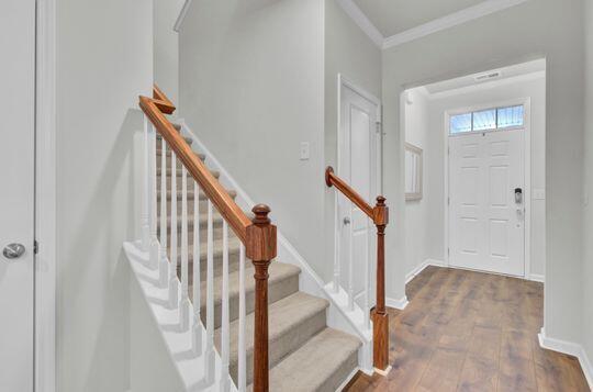 entryway with dark hardwood / wood-style floors and ornamental molding