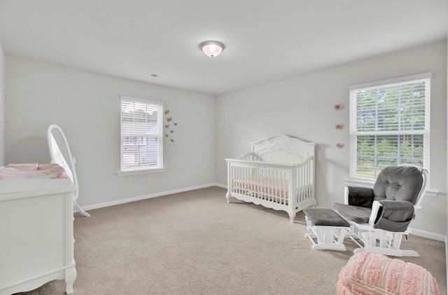 carpeted bedroom with a nursery area