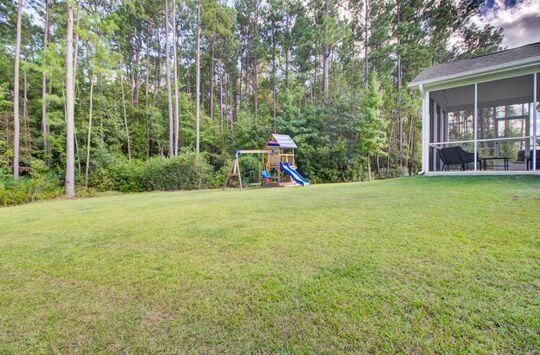 view of yard with a playground and a sunroom