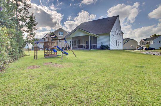 view of yard featuring a playground and a sunroom