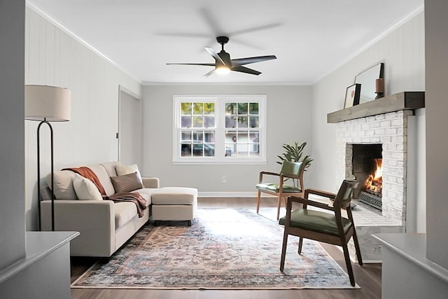 living room with crown molding, dark hardwood / wood-style floors, ceiling fan, and a fireplace