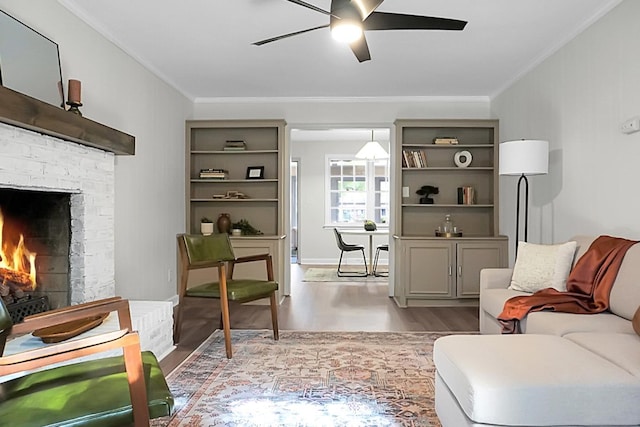 interior space with a fireplace, ornamental molding, light hardwood / wood-style floors, and ceiling fan