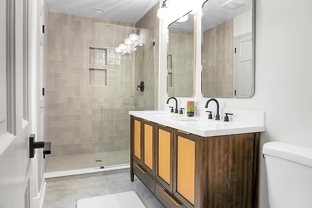 bathroom featuring vanity, toilet, and tiled shower