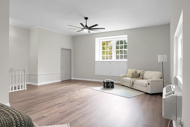 living area featuring wood-type flooring and ceiling fan