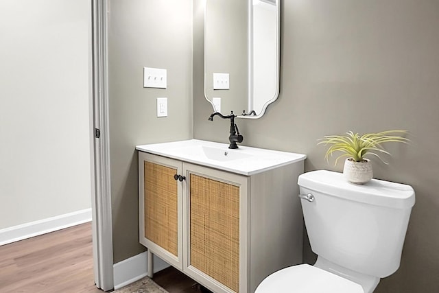 bathroom with hardwood / wood-style flooring, vanity, and toilet