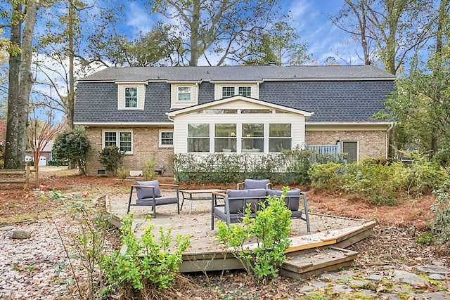 back of property featuring an outdoor living space, a sunroom, and a deck