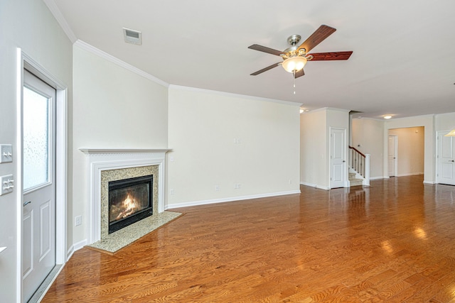 unfurnished living room with ceiling fan, a fireplace, hardwood / wood-style floors, and ornamental molding