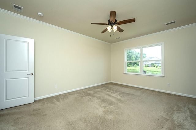 carpeted spare room with ceiling fan and ornamental molding