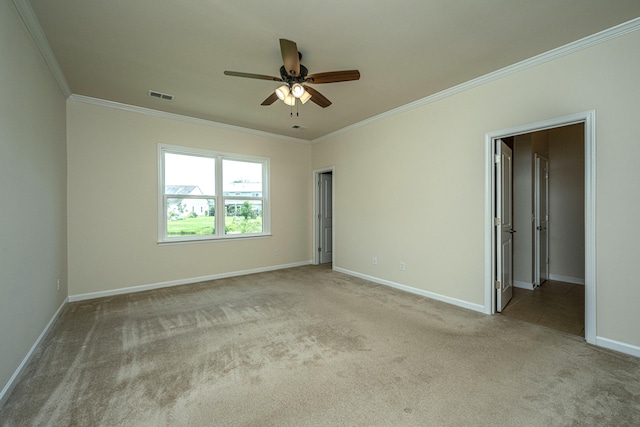 carpeted spare room with ceiling fan and ornamental molding