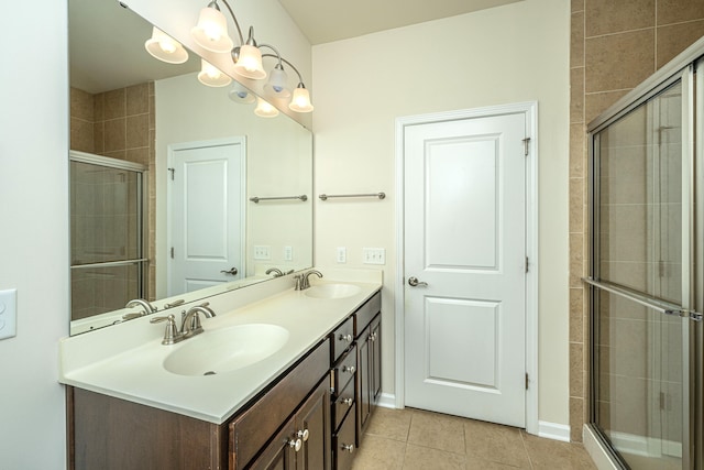 bathroom featuring tile patterned flooring, dual vanity, and a shower with shower door