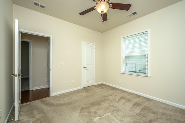 unfurnished bedroom with ceiling fan and light colored carpet