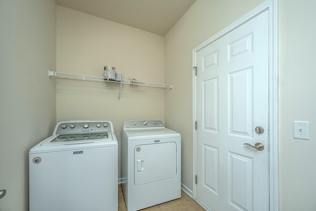 laundry room featuring washer and clothes dryer and light tile patterned floors