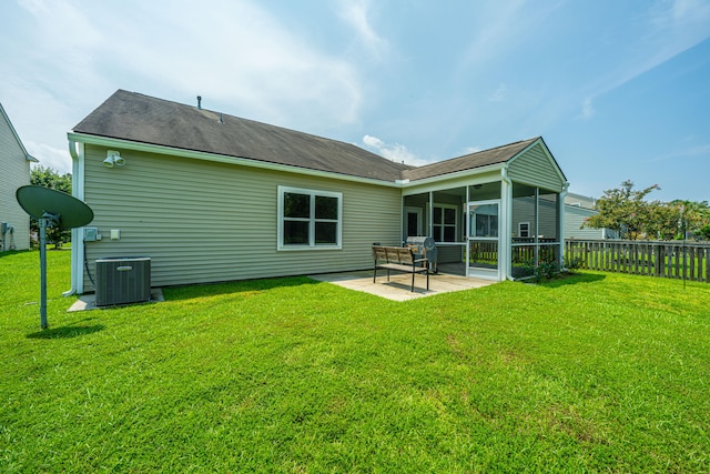 back of property featuring a lawn, a sunroom, a patio, and central AC