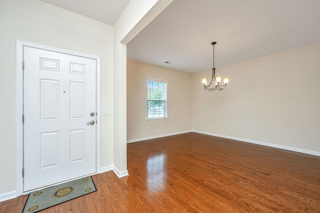 foyer entrance featuring a notable chandelier and wood-type flooring