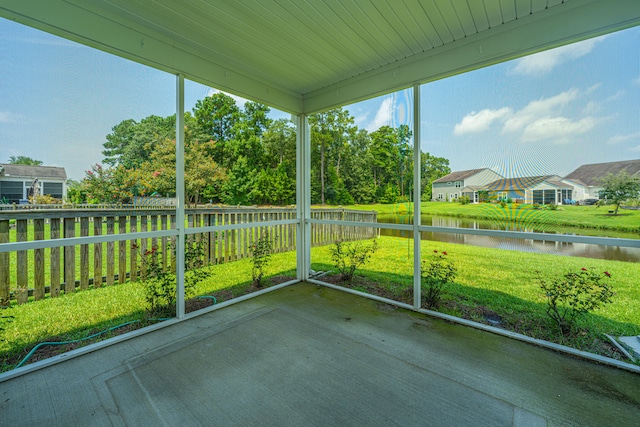 unfurnished sunroom with a water view