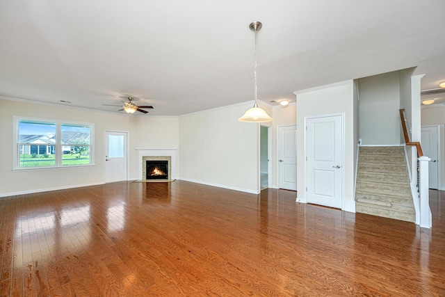 unfurnished living room with ceiling fan, crown molding, and wood-type flooring