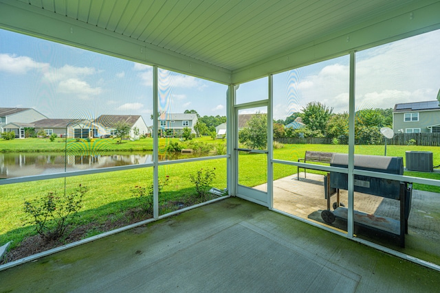 unfurnished sunroom featuring a water view