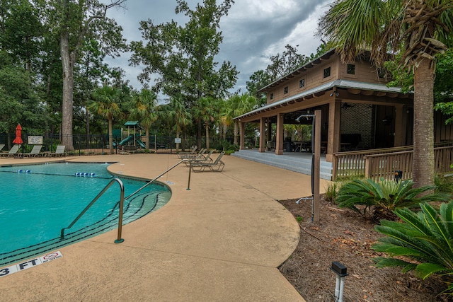 view of pool featuring a patio and a playground