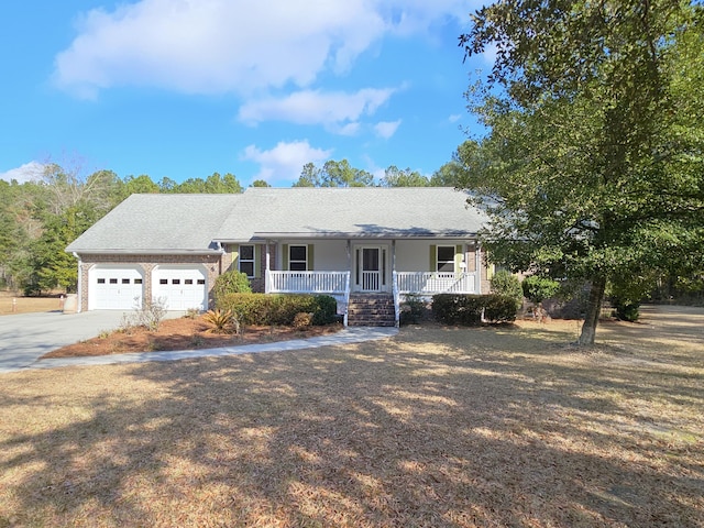 ranch-style house featuring driveway, covered porch, and a garage