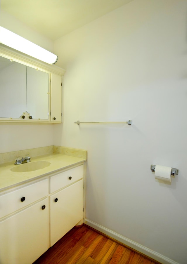 bathroom featuring wood finished floors, vanity, and baseboards